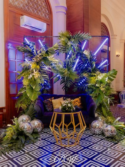 A tropical disco photo booth setup for a Sangeet in Goa. We combined lush greenery, neon lights, and disco balls for a cool, trendy vibe.