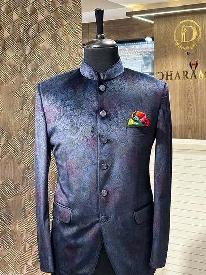A Jodhpuri jacket in a unique blue and purple abstract pattern. The colorful pocket square adds a perfect finishing touch to this artistic piece.