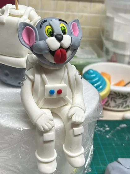 A work-in-progress shot of the fondant Tom figure for the Tom & Jerry in space cake. I hand-sculpt all my toppers to match the theme perfectly.