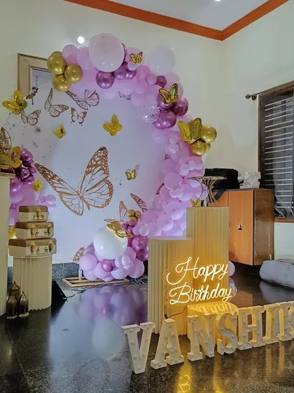 An intimate butterfly-themed setup for a home party. I used a circular backdrop, a neon sign, and marquee letters spelling out the name.