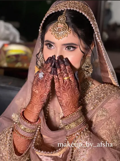 A classic shy bride pose. Her dusty pink outfit is so elegant, and the makeup is soft and romantic.