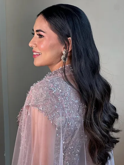 A side profile showcasing the soft waves and radiant cheek highlight for this sangeet look. The pink shimmer on the eyes adds a touch of color that ties the whole look together beautifully.
