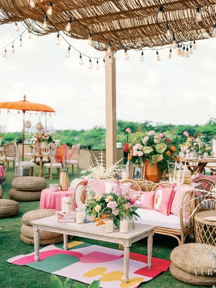 A cozy seating area at 'Villa Brissa' under a thatched roof with string lights. The mix of rattan furniture, jute poufs, and a colorful rug created a warm and tranquil vibe.