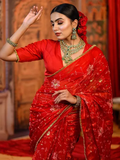 A dynamic pose of the red saree look, showing how makeup looks beautiful from every angle.