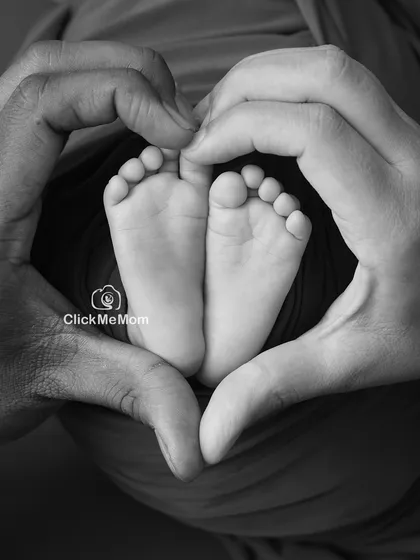 Sometimes the most powerful stories are told without color. This black and white portrait captures the love that surrounds your new baby, with parents' hands forming a heart around those perfect little feet.