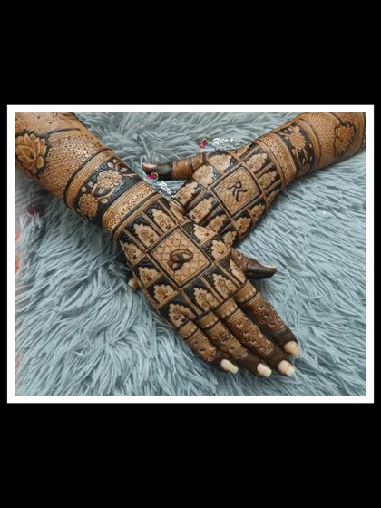 A close-up of a geometric and floral pattern on the hand, showing the clean lines and detailed fill work.