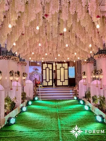 A dreamy pastel walkway perfect for a reception. The ceiling is covered in hanging white wisteria, creating a magical canopy for guests to walk through.