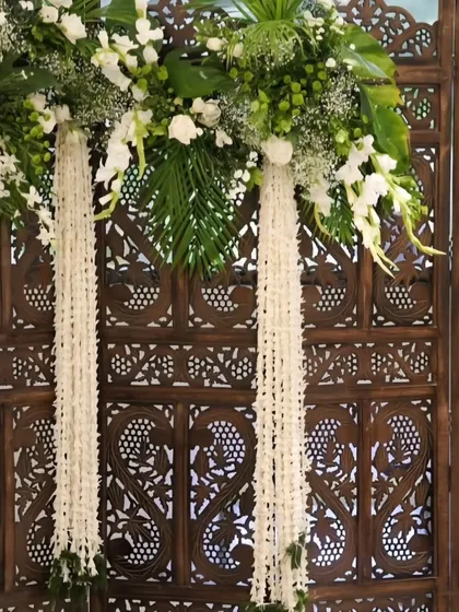 A close-up of the floral arrangement on the wooden screen. I used a mix of fresh white flowers and green leaves to create a look that is both classic and refreshing.