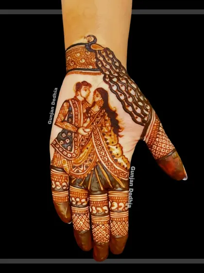 A classic couple portrait on the palm, crowned with a majestic peacock design. This combines storytelling with traditional Indian mehendi art.