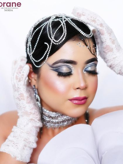 A beautiful and serene portrait that highlights the intricate details of the headpiece and makeup.