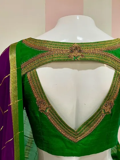 A closer view of the back of the green Mysore silk blouse, showing the detailed zardosi embroidery framing the cutout.