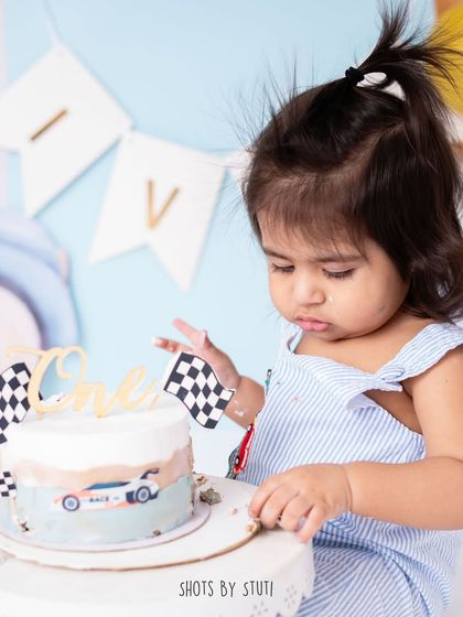 A close up of the car themed cake and the birthday boy. Themed cake smashes are a fantastic way to celebrate your child's interests, even at one year old.