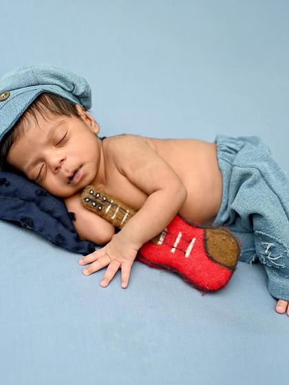 A future rockstar in the making. This little one is sleeping peacefully with his miniature guitar, dressed in a cool denim outfit.