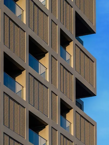 The geometric precision of the facade against a clear blue sky highlights the project's clean, modern aesthetic.