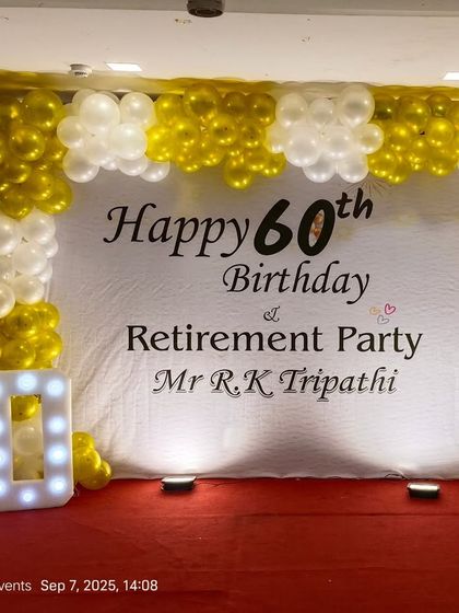 A clean and classic setup for a combined 60th birthday and retirement party. The design includes a simple white backdrop with custom text, a gold and white balloon frame, and a "60" marquee number.