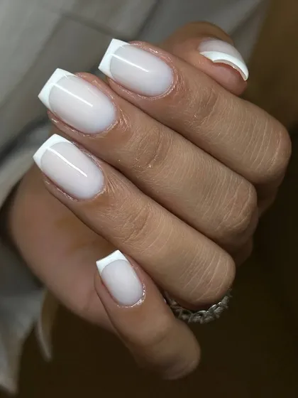 A modern, milky French manicure on square-shaped extensions. The semi-opaque white base softens the look for a chic and updated feel.