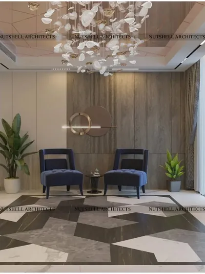 A welcoming entrance foyer designed with geometric marble flooring and plush blue armchairs. The space is anchored by a custom carved wooden door and a sculptural chandelier, creating an immediate sense of luxury.