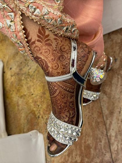A shot of the bridal foot henna, showing how it looks with beautiful wedding footwear.