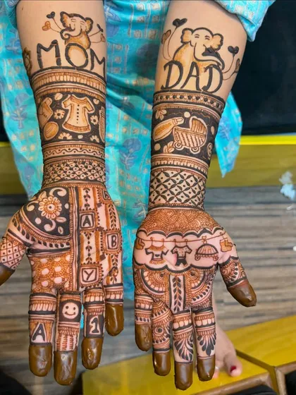 A creative baby shower design with "Mom" and "Dad" written on the arms, along with cute baby clothes, a stroller, and alphabet blocks on the palms.