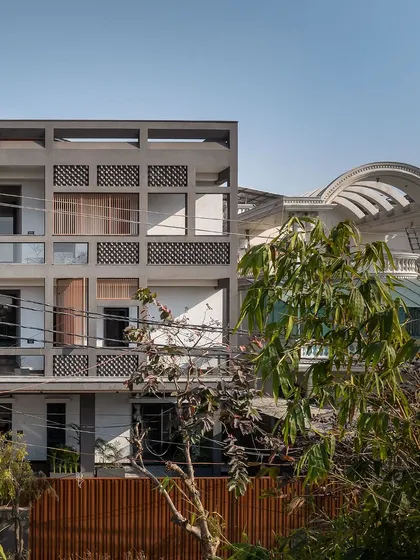 The strong, grid-like structure of the facade is a defining feature of the project. It provides a sense of security and order, contrasting with the more organic, refined spaces within.