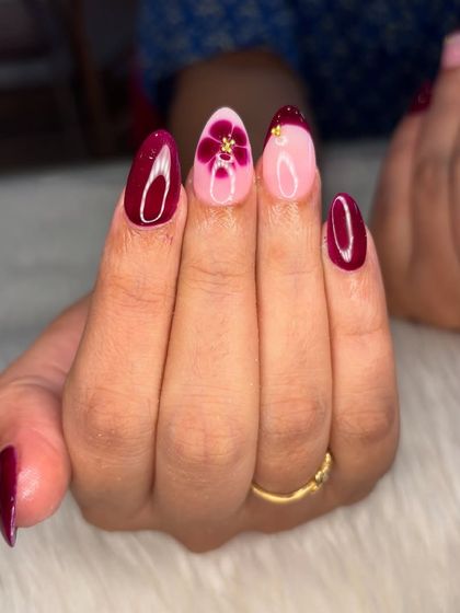 A close-up of the beautiful maroon blooming flower accent nail.