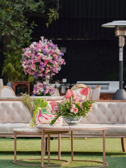 A more relaxed seating area on the lawn, with comfortable sofas and floral arrangements, perfect for a daytime event.