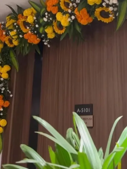 A beautiful floral toran made of yellow and orange marigolds, adorning the main door for a housewarming ceremony.