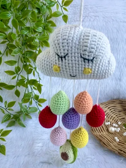 I designed this sleepy cloud mobile to be a sweet and gentle addition to a baby’s room. With colorful raindrops and a special little avocado, it’s a whimsical piece of nursery decor that adds a touch of handmade love above a crib.