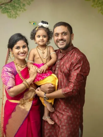A classic family portrait with your little one dressed as Krishna. This setup against a painted backdrop offers a timeless and traditional way to capture your family during the festive season.