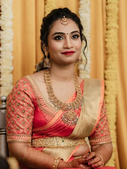 Another beautiful shot of Dr. Pooja. Her makeup features a classic red lip and softly defined eyes, a perfect combination for traditional South Indian festivities.