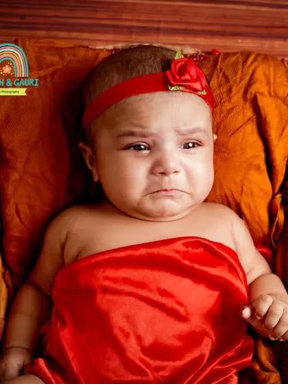 Even a little pout is an adorable memory to capture. This 2-month-old's expressive face is the focus of this red-themed shot.