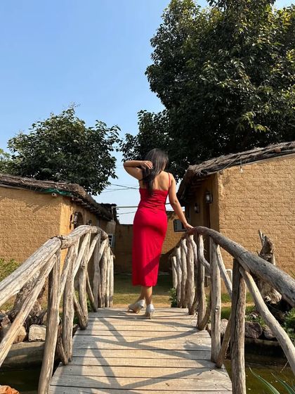 A back view of the red slit dress, highlighting its simple yet elegant silhouette. Sometimes, the most impactful looks are the ones that are clean and confident.