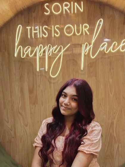 Posing in front of the iconic "happy place" sign with her new, vibrant red hair. A perfect photo to capture the joy of a fresh look.