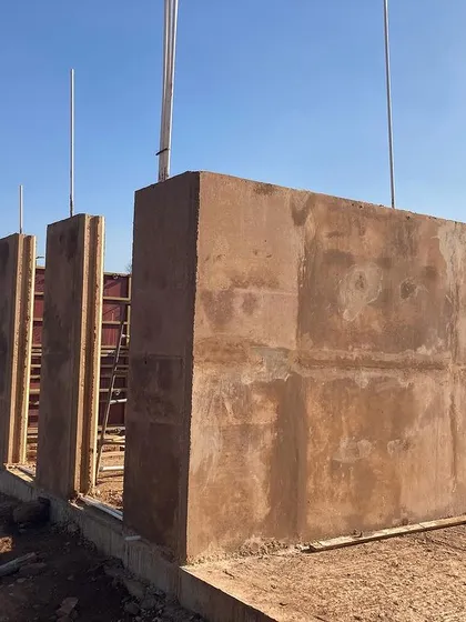 The completed rammed earth walls of the Unnathi Farm pavilion, showing the beautiful texture and color derived from the local soil.