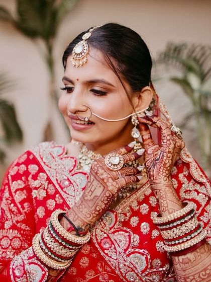 This candid shot shows the bride adjusting her earring, giving a glimpse of the intricate details of her look.