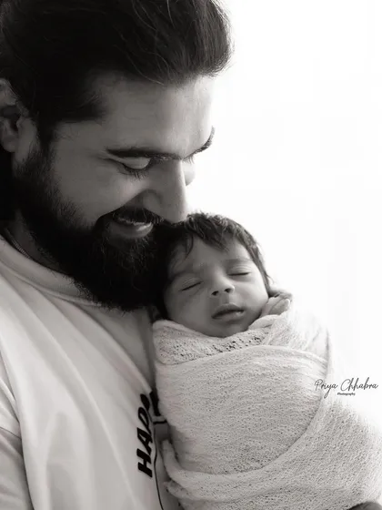 A father's gentle embrace. This black and white portrait of a dad and his newborn son is full of warmth and tenderness, a memory he will always treasure.