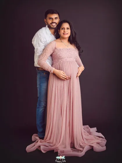 A beautiful full-length portrait of the couple. The flowing pink lace gown and their loving embrace make for a timeless maternity photograph.
