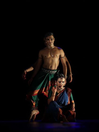 Another angle of a complex pose from 'Nagamandala', showing the physical trust and support required between the dancers.