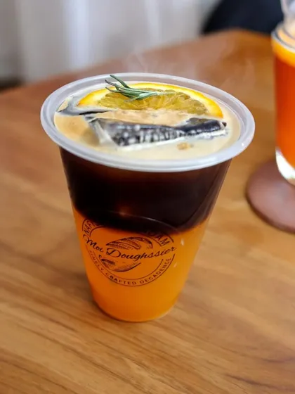 For a refreshing twist on your coffee, try my Orange Americano. It's a vibrant combination of a bold espresso shot poured over chilled orange juice, garnished with a slice of orange and a sprig of rosemary.