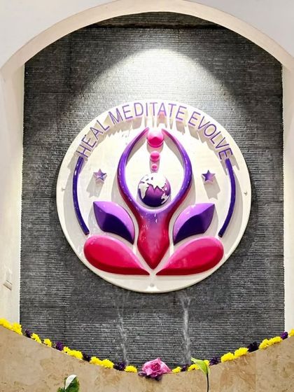The 'Heal, Meditate, Evolve' emblem of Samyama, installed as a water feature at our Spiritual Centre. This beautiful installation represents the core of our mission and the continuous flow of spiritual energy.