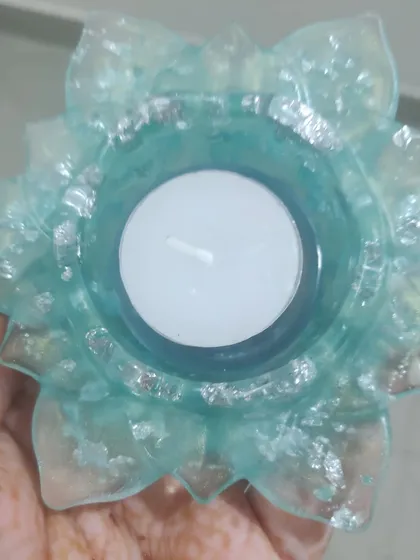 Here is a simple yet elegant T-light holder I crafted. Made from a translucent light blue resin mixed with delicate silver flakes, this piece creates a beautiful glow when a candle is lit inside. These make for lovely, handcrafted wedding favors or festive decor for your home.