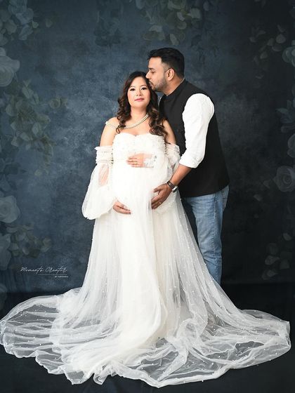 A tender moment between father and mother-to-be. His gentle kiss on her forehead adds a layer of warmth and affection to this beautiful family portrait.