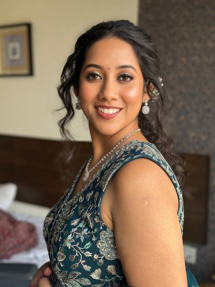 A beautiful side profile of the Mehandi look, showcasing the soft curls and the natural, radiant makeup.