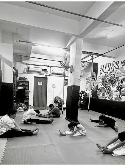What seems impossible today will one day become your warm-up. A group of students work on their forward fold stretch.