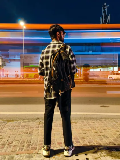A long-exposure portrait where the subject stands still against the blur of city traffic. This technique creates a powerful contrast between the calm individual and the fast-paced environment.
