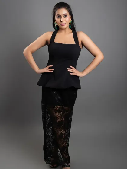 Here, we switched to a classic grey backdrop to complement the elegant black peplum top and lace skirt. This kind of studio portrait is ideal for showcasing evening wear, emphasizing the texture and silhouette of the garment for a sophisticated brand image.