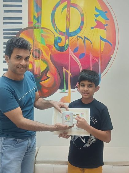 Our student Divit Kansal proudly receives a gift from his mentor after completing Basic Level 3 in guitar. We celebrate every milestone with our students.