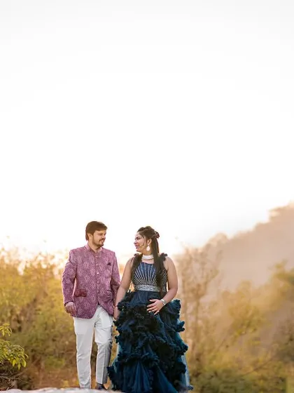 A walk through a misty, golden landscape by the river. The unique colors of their outfits and the soft light create a dreamy, almost painterly pre-wedding photograph.