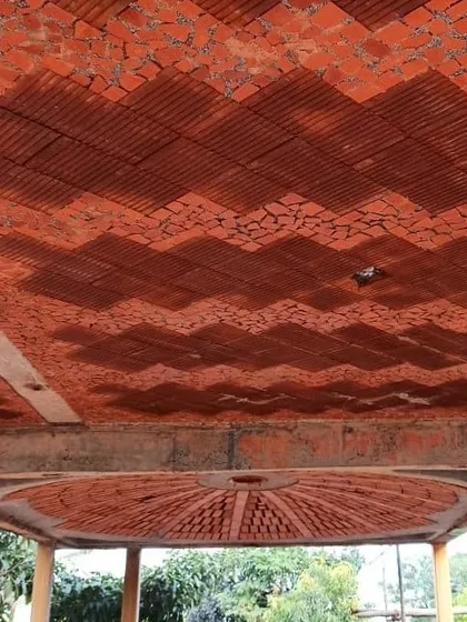 We find beauty in reuse. This ceiling features a mosaic made from broken terracotta tiles, creating a visually stunning pattern while upcycling materials that would otherwise be wasted. The design includes a brick dome for a fan.
