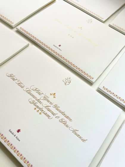 A close-up of the wedding invitation calligraphy. The mix of a traditional design with elegant, handwritten names creates a beautiful balance.